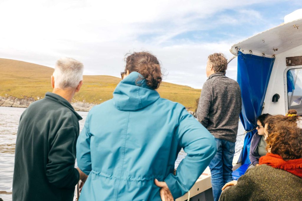 Passengers at the front of the boat looking at the coast