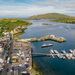 Aerial view of Portmagee harbour featuring boats ready for Skellig Michael Tours and the green landscape. 