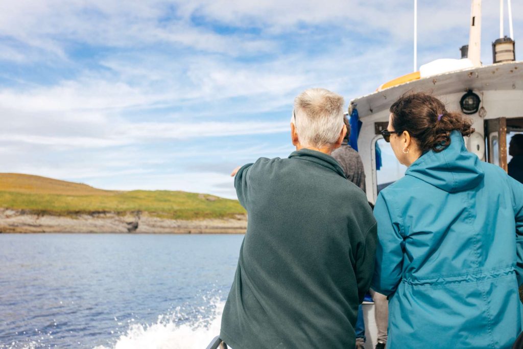 A passenger pointing at the coast from the boat