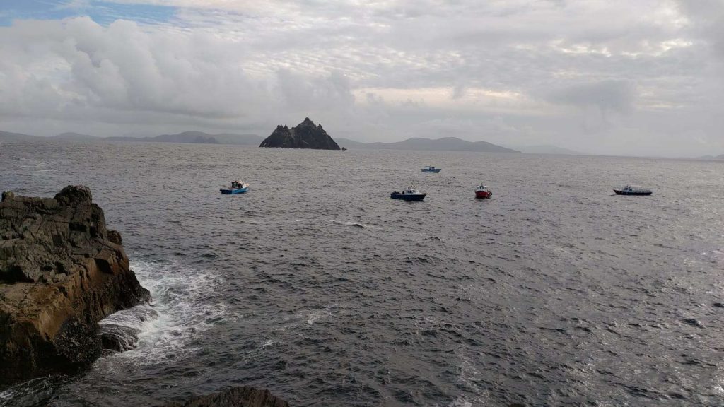 Small boats on the sea, with Skellig Michael in the distance