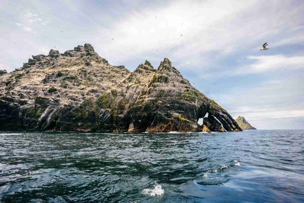 Dramatic Skellig Michael view from the sea, showing rugged cliffs and birdlife. Explore Skellig Michael Tours from Portmagee today.