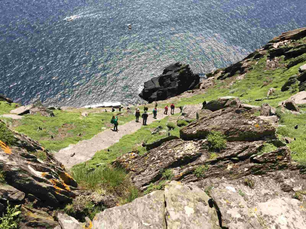 Visitors walking up the path on Skellig Michael above the sea